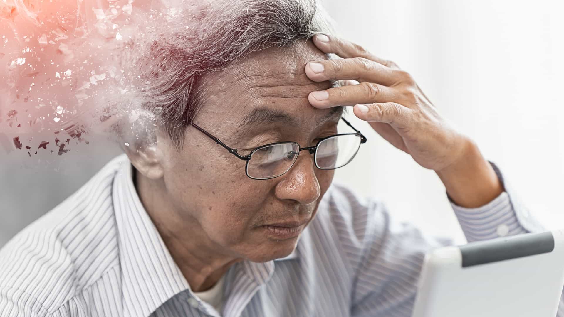 Older man holding his head with part of his head dissolving