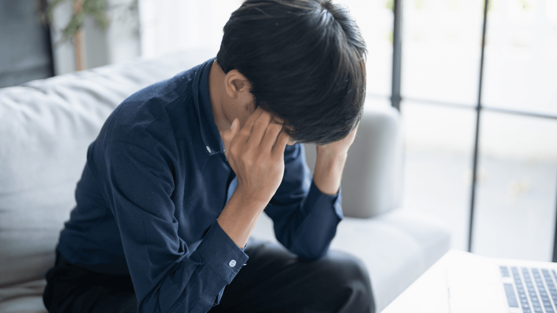 A man sitting alone with his face in his hands