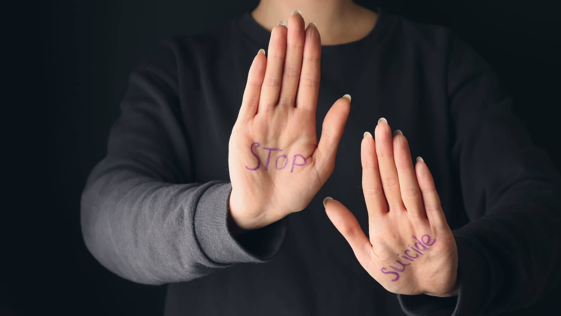 Hands are held up with the words "STOP" and "Suicide"