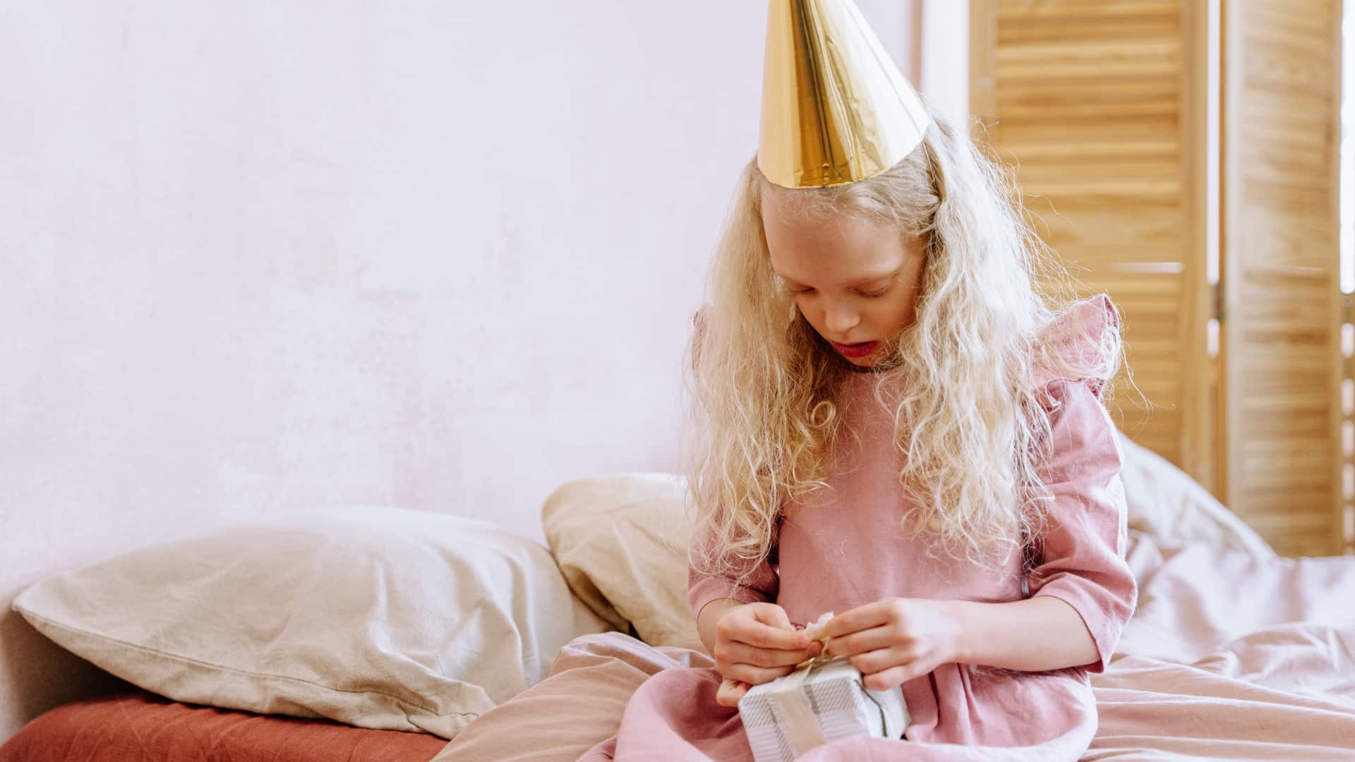 A girl with a party hat is looking down