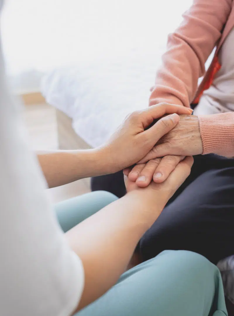 A lady holding hands of an old lady