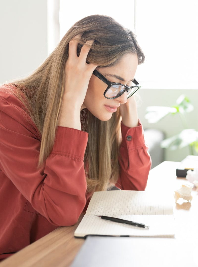 A woman holds her head in frustration