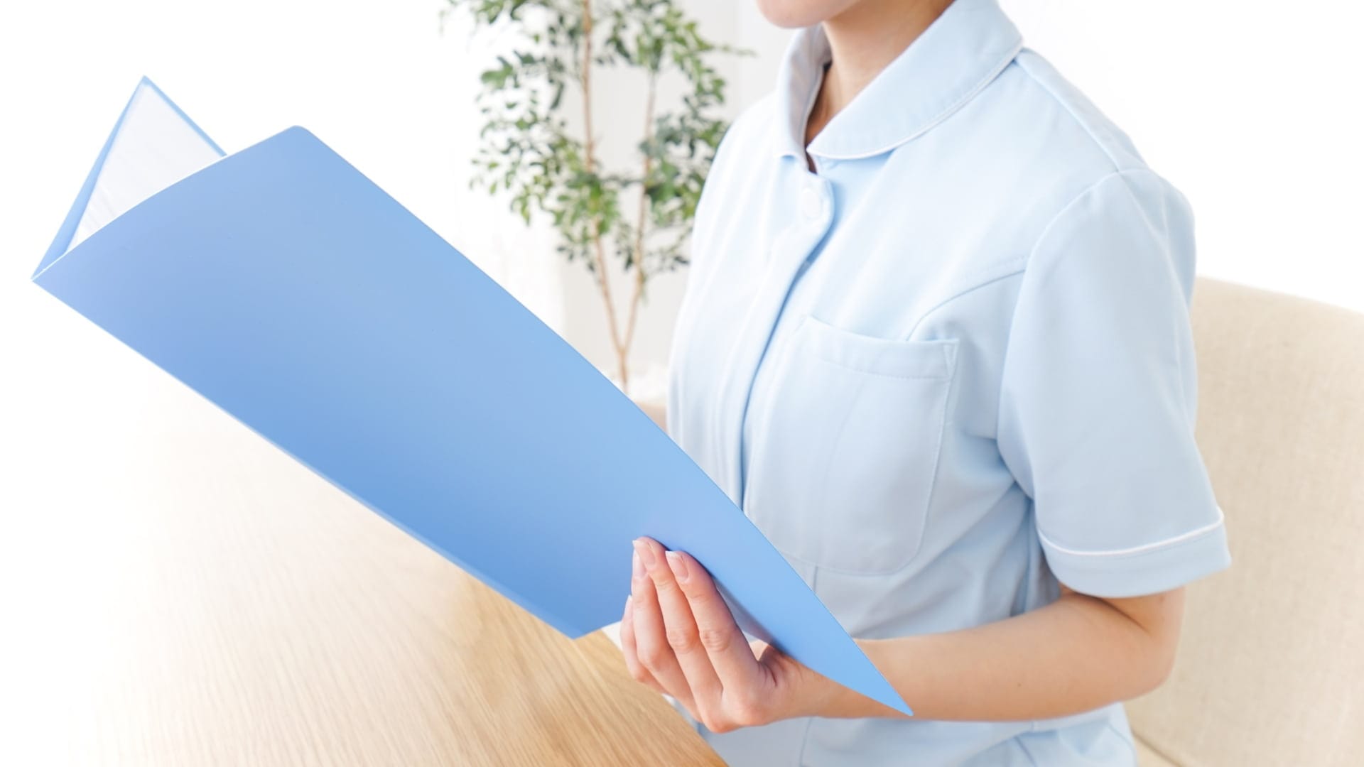 A professional holding a blue folder