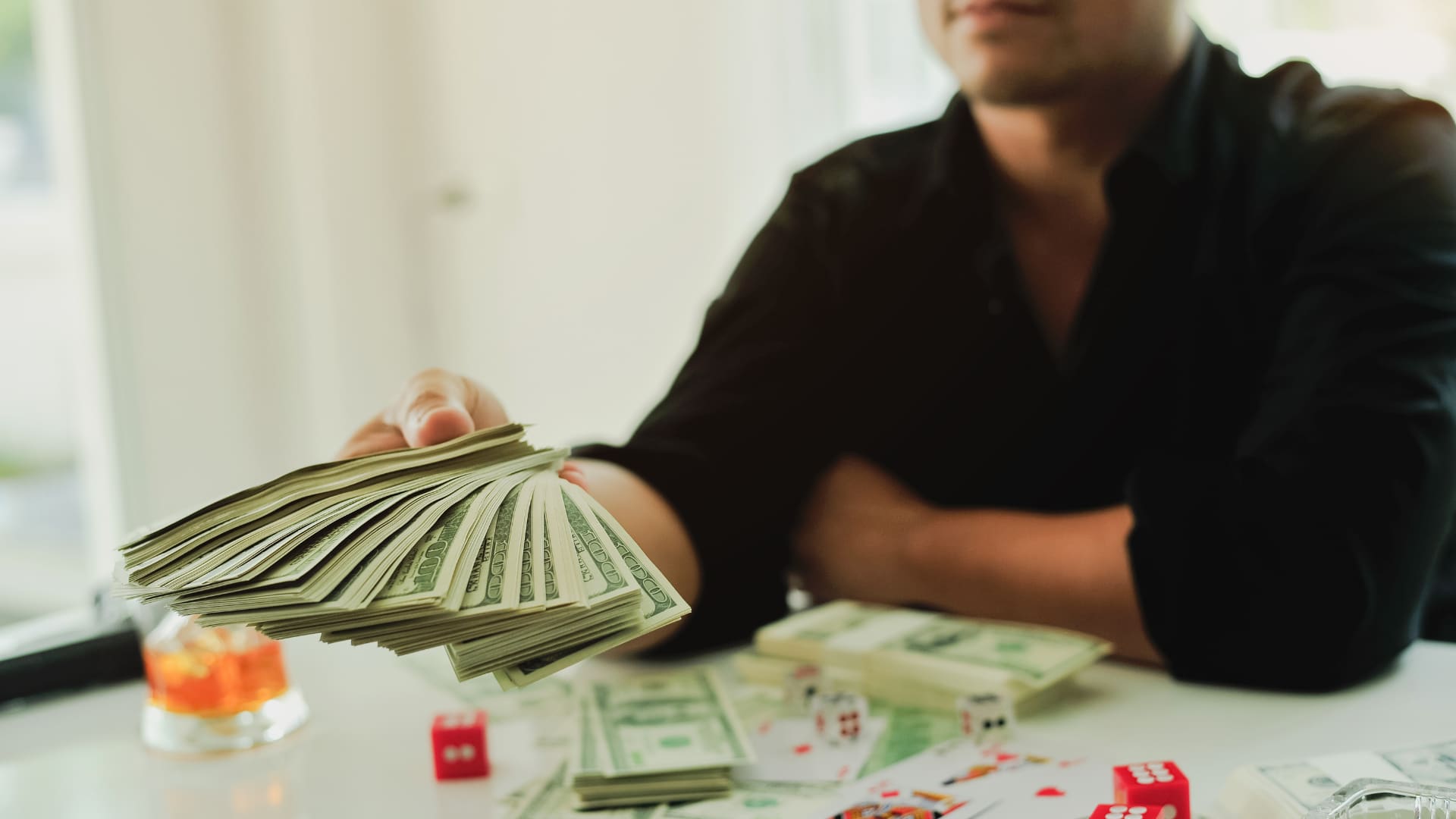 A person hands over a large wad of cash