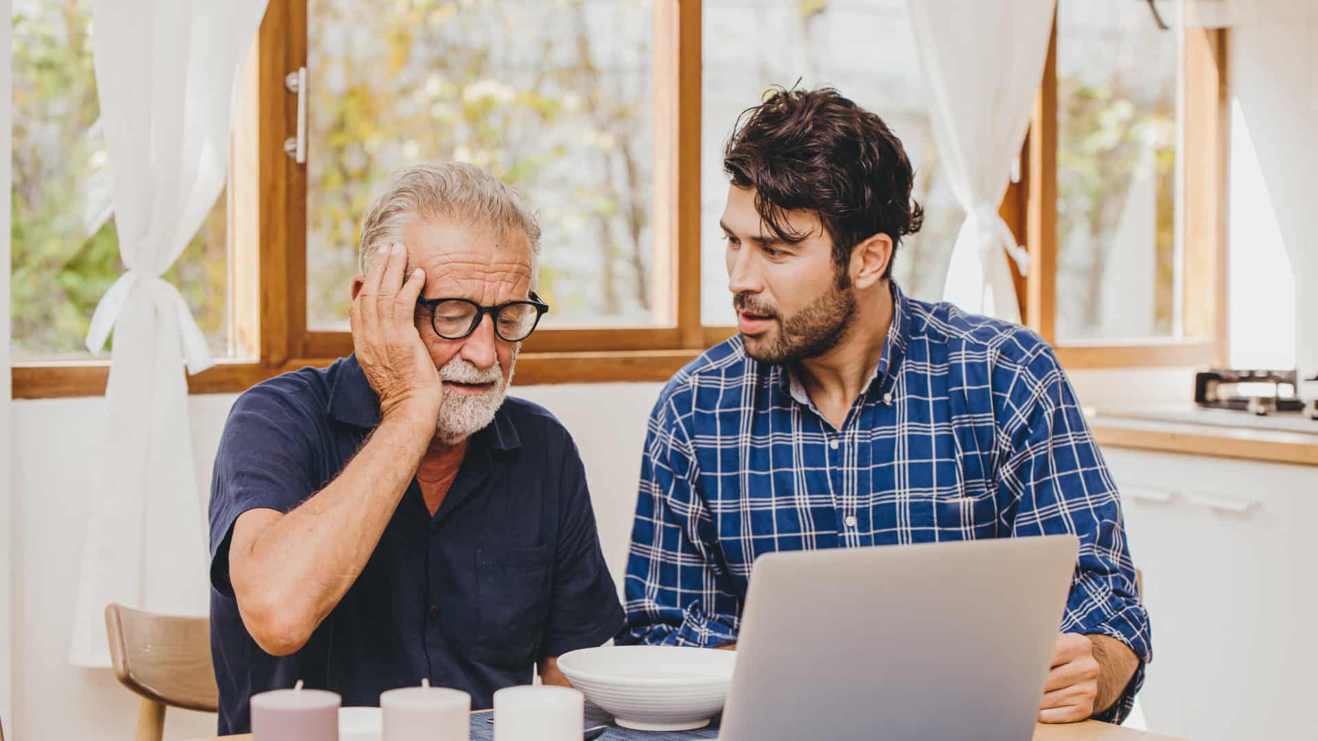 A worried younger man talks to an older man