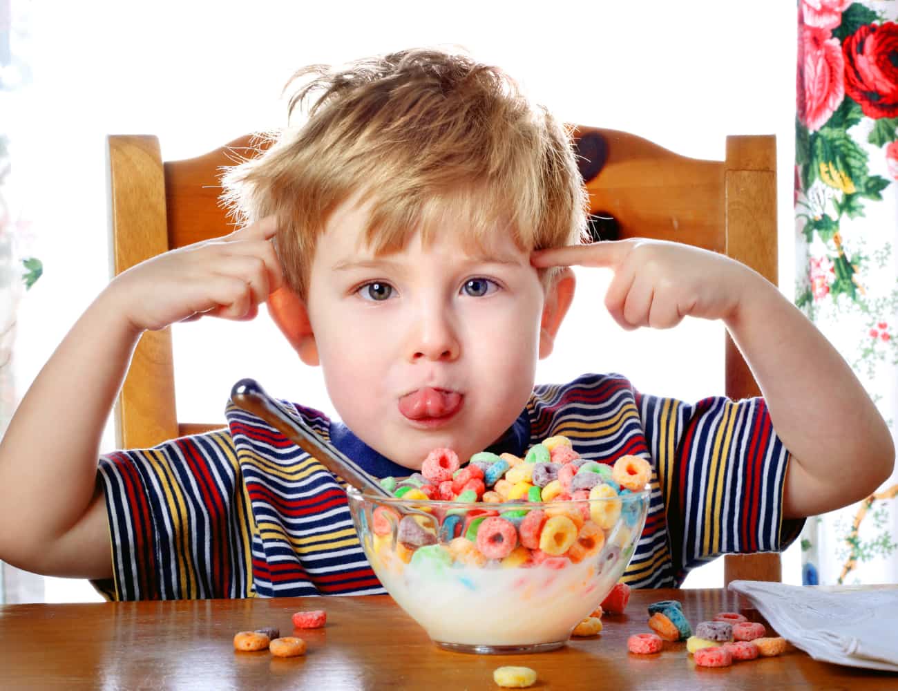 A child with adhd sitting with a bowl of cheeros.